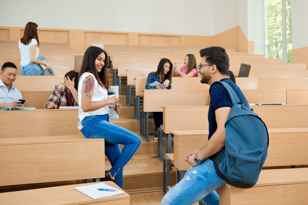 Backview of students communicating in university.