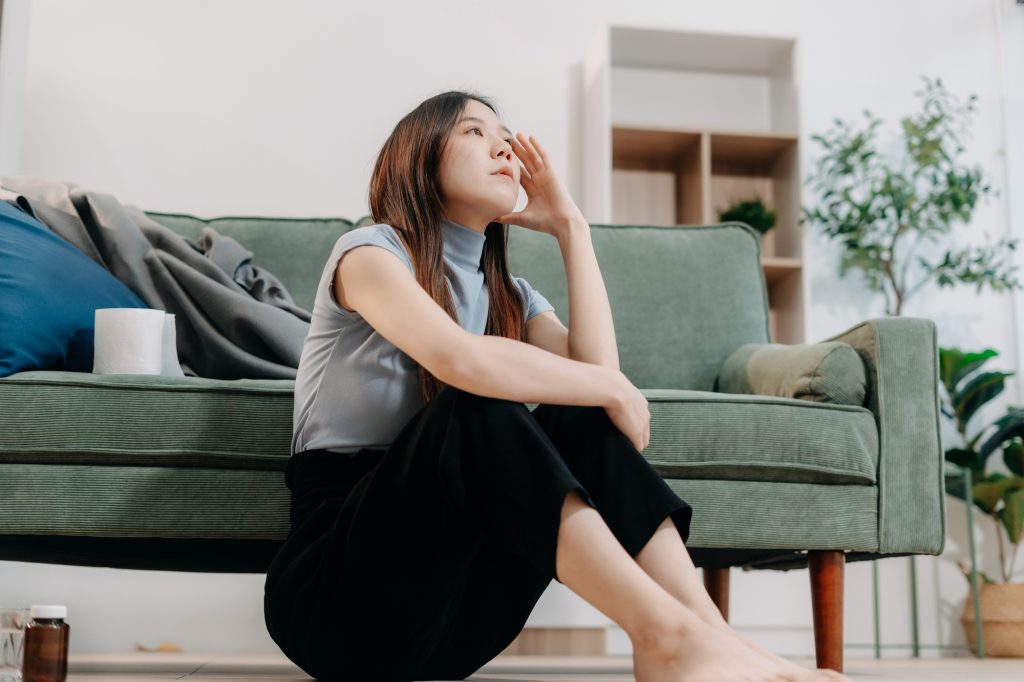 Lonely Depressed Young Woman Sitting on Sofa, Sad Mood.