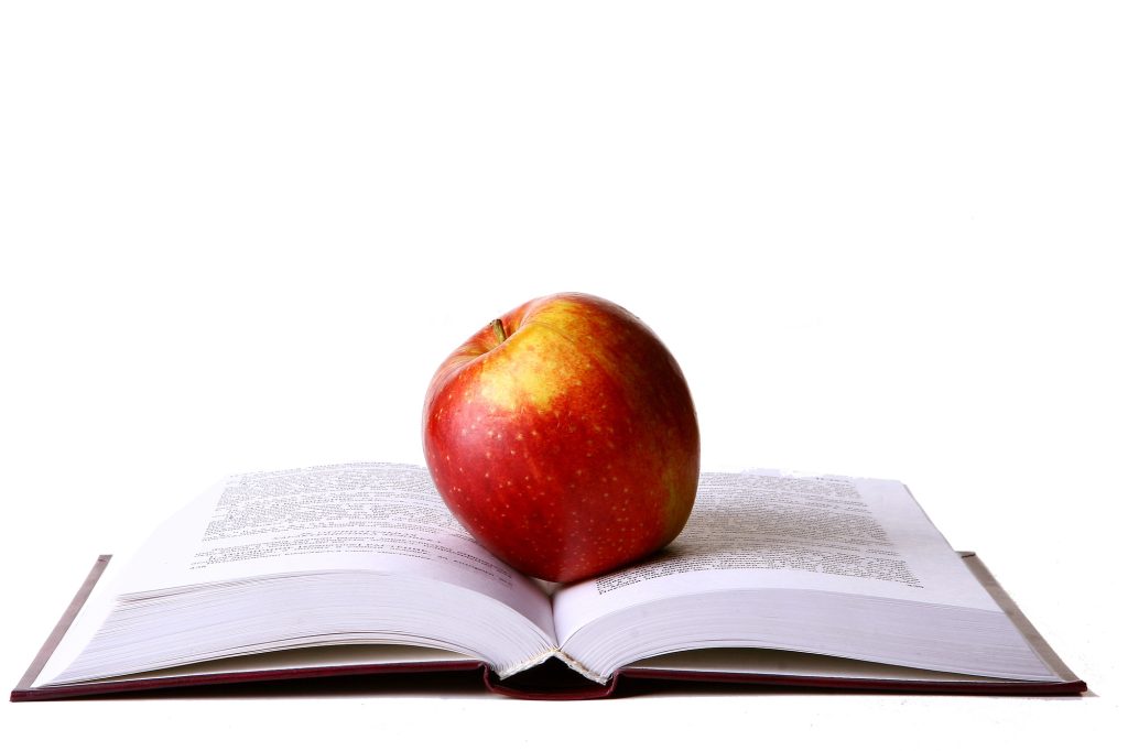 Opened student book with red apple